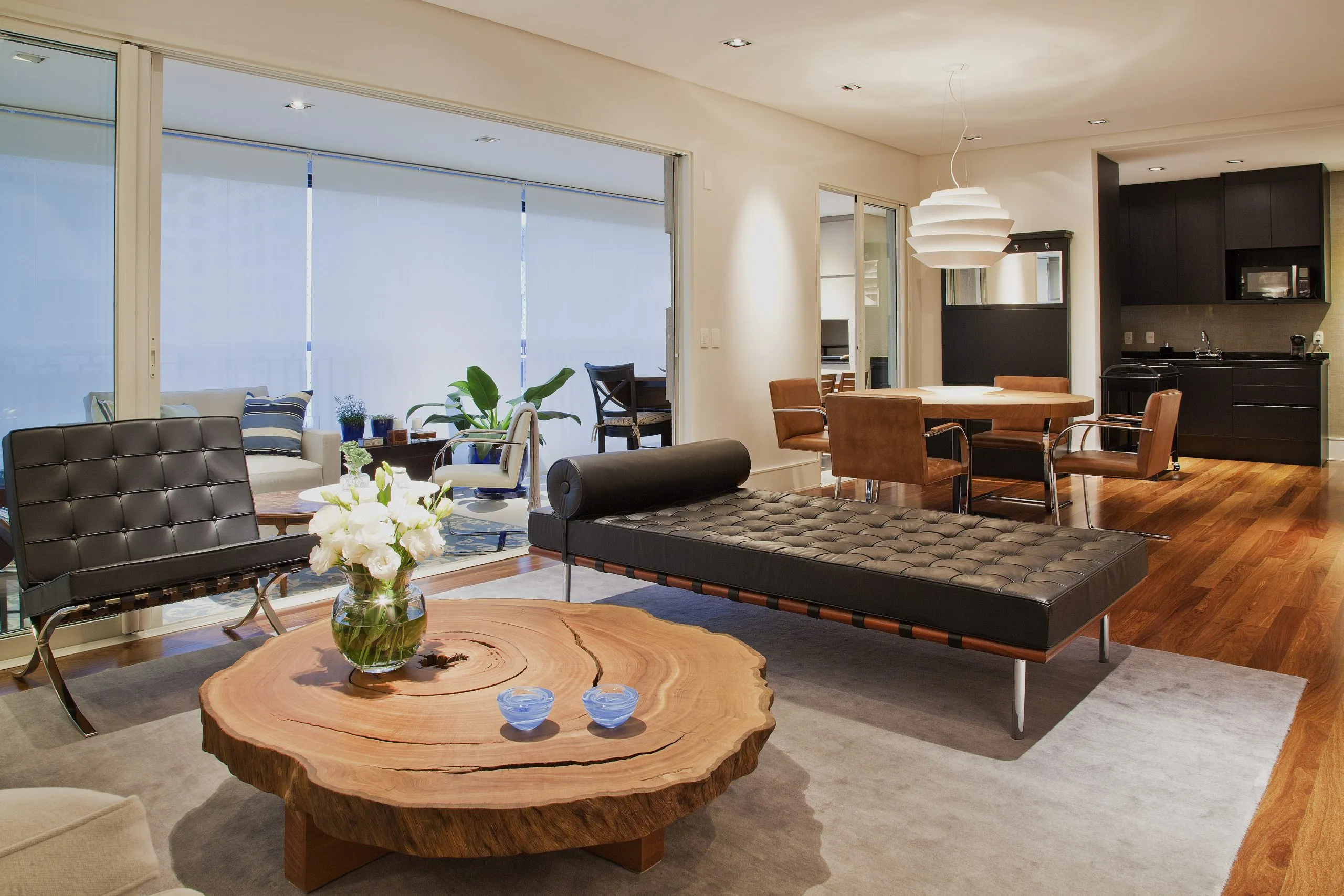 Sala de estar com daybed de couro e mesa de tronco