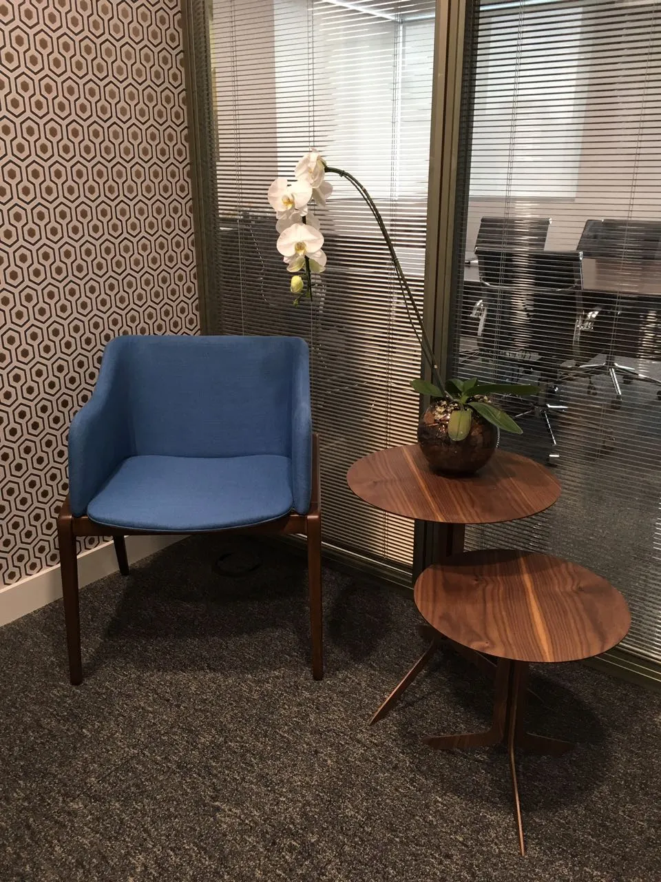 Poltrona azul com mesas laterais de madeira em escritório