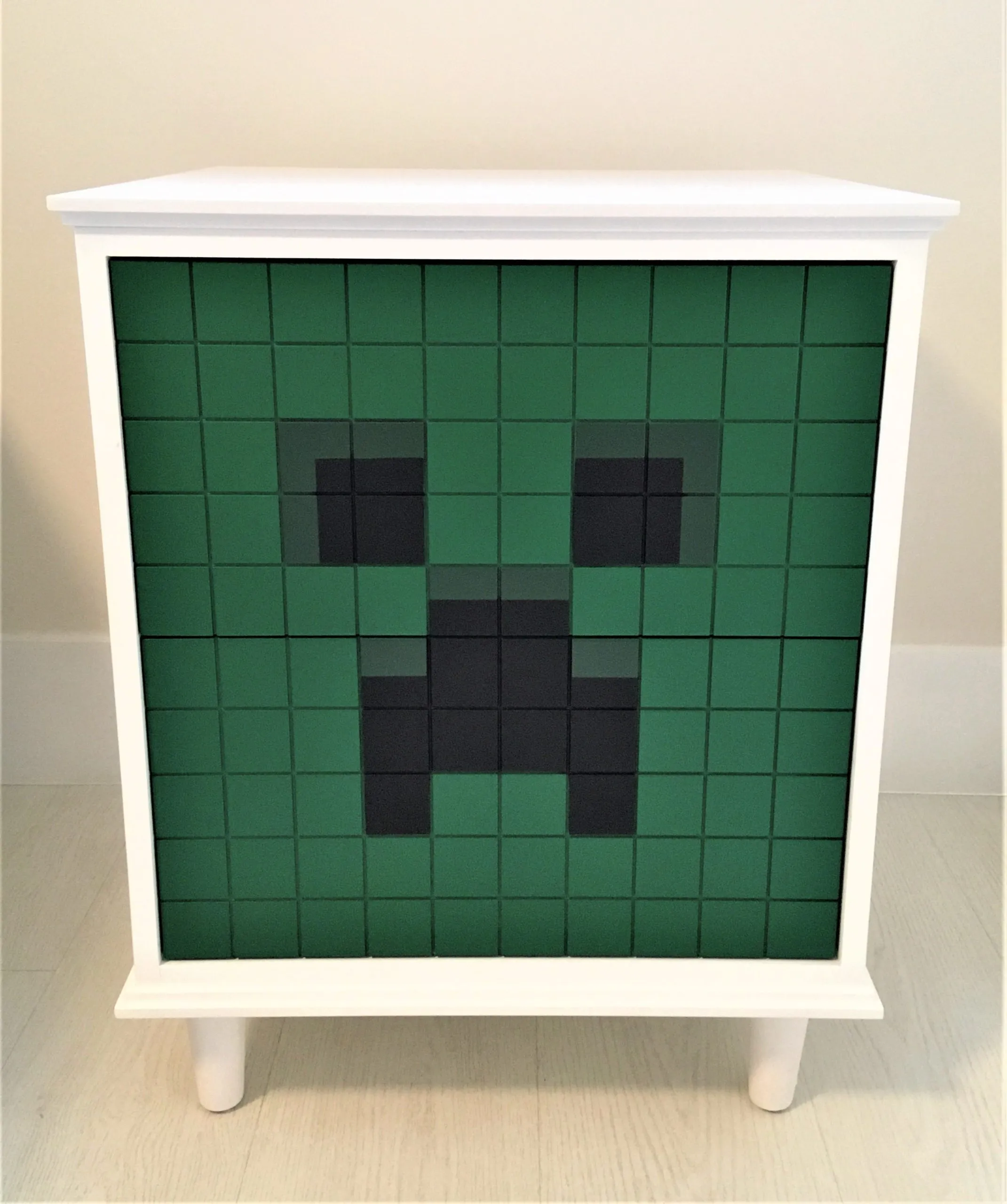 Criado-mudo branco com frente em mosaico do Creeper de Minecraft
